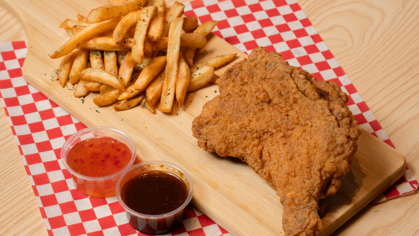 fried chicken leg with fries on a table