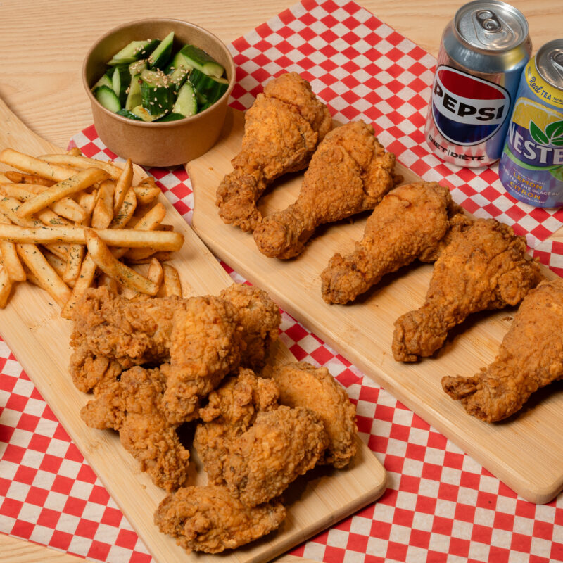 plates of fried chicken wings, sides, and drinks